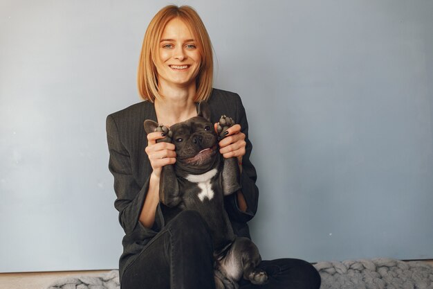 Elegante vrouw in een zwart pak met zwarte bulldog