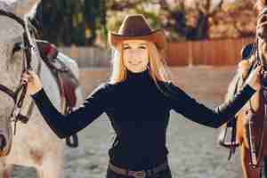 Gratis foto elegantsmeisje met een paard in een boerderij