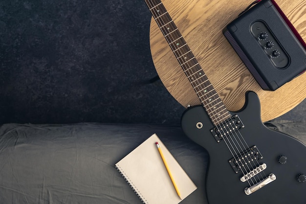 Elektrische gitaar notepad en muziek luidspreker op een tafel in de kamer top view