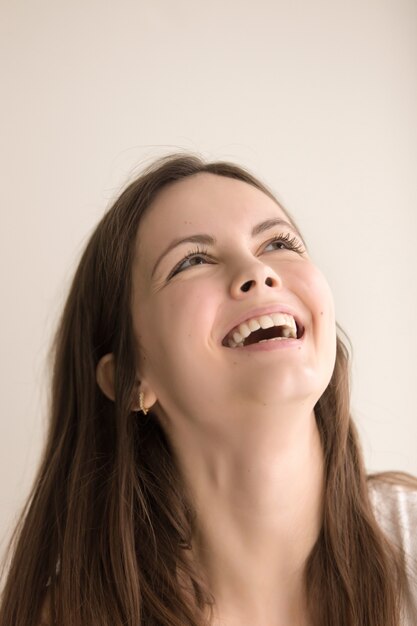 Emotioneel headshotportret van blije jonge vrouw