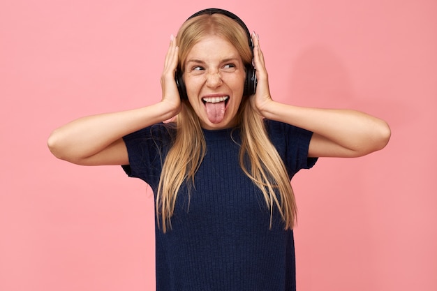 Gratis foto emotionele schattige tienermeisje genieten van favoriete muzieknummers in draadloze hoofdtelefoons