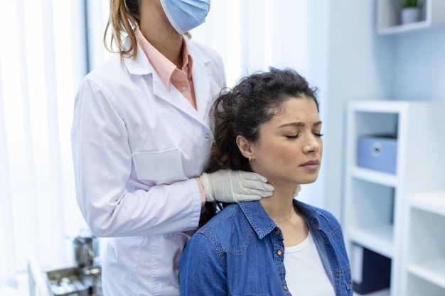 Endocrinoloog die keel van jonge vrouw in kliniek onderzoekt Vrouwen met schildkliertest Endocrinologische hormonen en behandeling Ontsteking van de zere keel