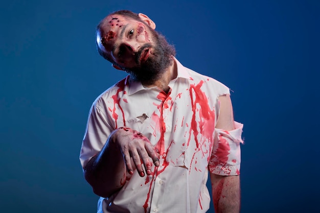 Gratis foto enge ondode zombie die er gek kwaad uitziet, bloed op het shirt heeft en een gevaarlijke agressieve bloederige blik. griezelig apocalyptisch lijk met lelijke vuile littekens en wonden, hersenetende demon.