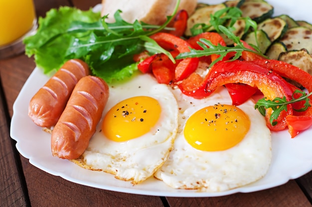 Engels ontbijt - gebakken eieren, worstjes, courgette en paprika