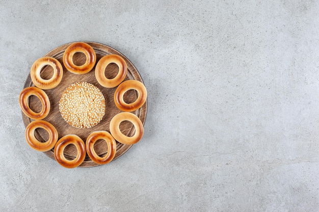 Enig koekje omringd door sushki op een houten bord op marmeren achtergrond. Hoge kwaliteit foto