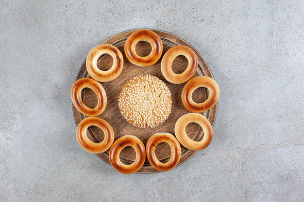 Enig koekje omringd door sushki op een houten bord op marmeren oppervlak