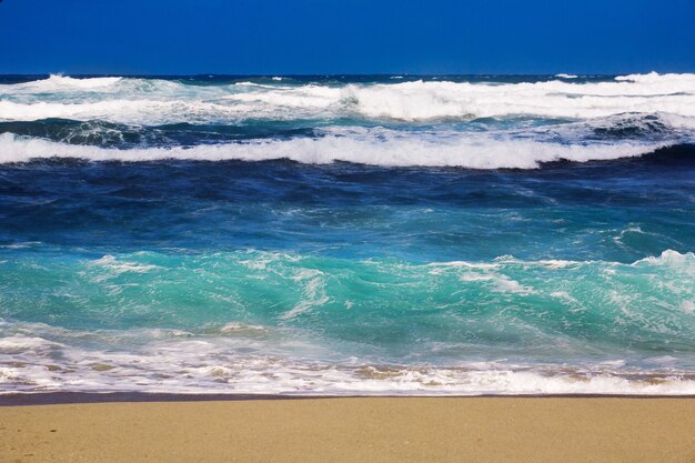Enorme golven van de zee die op het zandstrand beuken