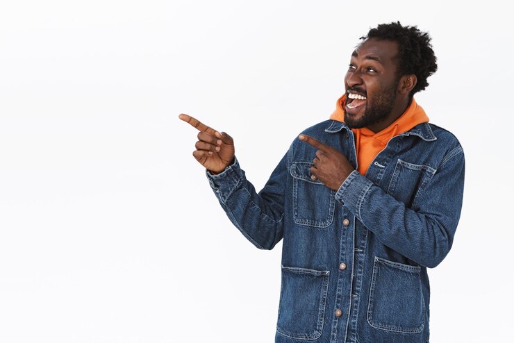 Gratis Foto enthousiaste, gelukkige en vrolijke knappe afro-amerikaanse man in spijkerjasje, oranje hoodie, wordt spannend