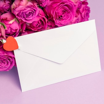 Envelop en rozen boeket op kleur achtergrond.