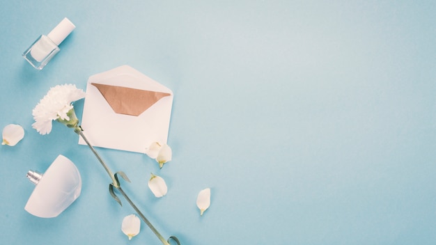 Envelop met witte bloem en parfum op tafel