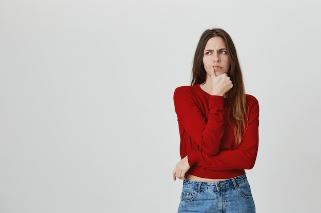 Ernstig ogende aantrekkelijke vrouw denken, moeilijke keuze maken