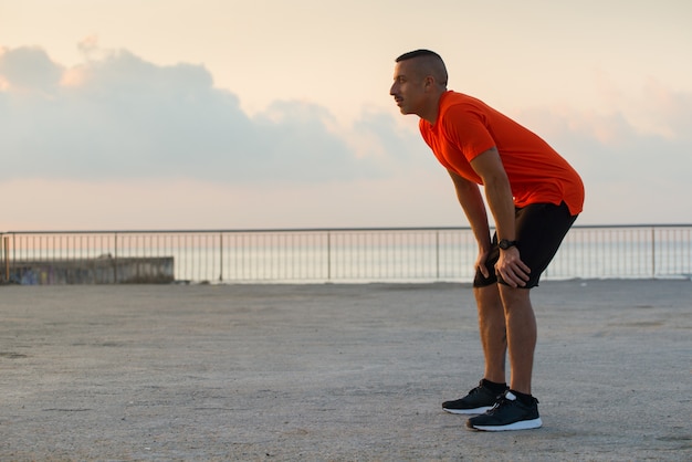 Ernstige atleet die adem terugwint na het joggen