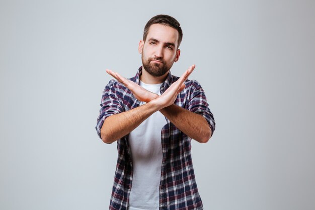 Ernstige bebaarde man in shirt met stop gebaar