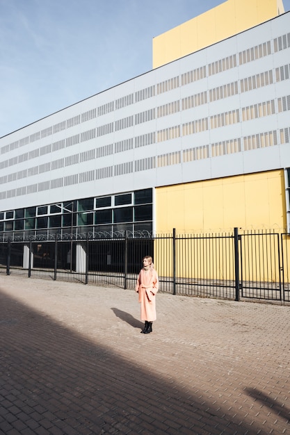 Ernstige jonge blonde dame die in openlucht loopt. opzij kijken.