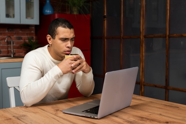 Ernstige jonge man op zoek naar een laptop