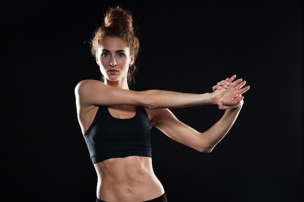 Ernstige jonge sport dame maken rekoefeningen.