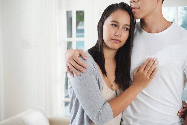 Ernstige jonge vrouw diep in gedachten knuffelen haar vriendje