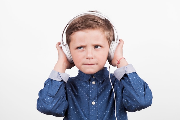 Ernstige jongen die aan muziek luistert