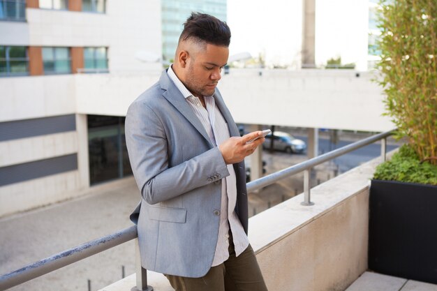 Ernstige manager die zijn tijdschema op telefoon onderzoekt