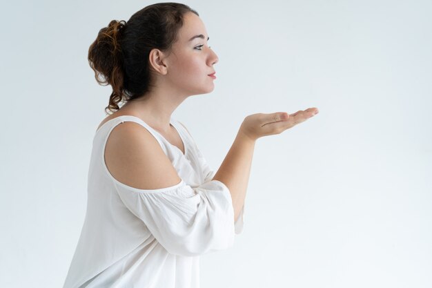 Ernstige mooie vrouw die luchtkus verzendt