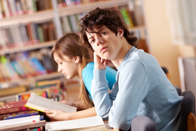 Gratis foto ernstige tiener in de bibliotheek