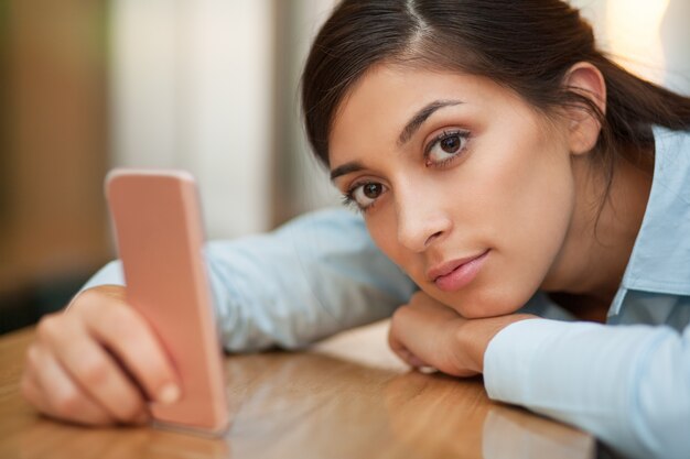 Ernstige Vrouw die op Teller met Smartphone