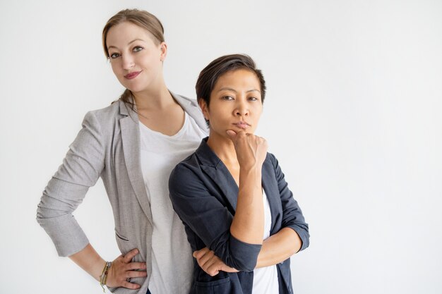 Ernstige vrouwen die zich en camera bekijken verenigen