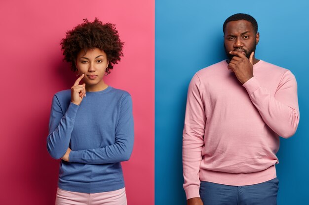 Ernstige vrouwen en mannen met een donkere huidskleur hebben diepe gedachten, kijken nadenkend, nemen een beslissing of denken na over plannen
