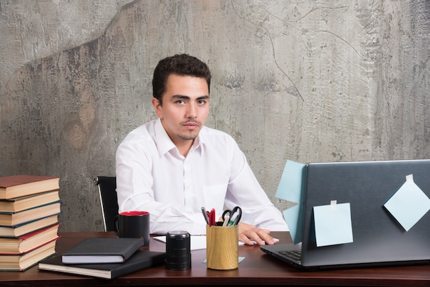 Ernstige zakenman camera kijken naar het bureau.