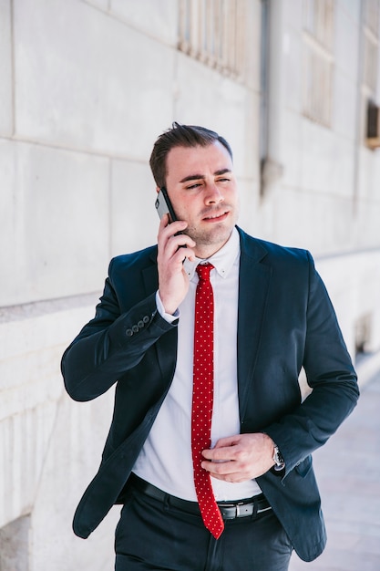 Ernstige zakenman die op telefoon op straat spreekt