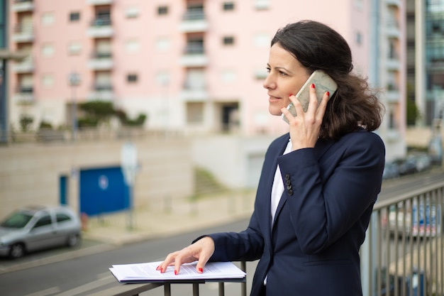 Ernstige zakenvrouw praten door smartphone