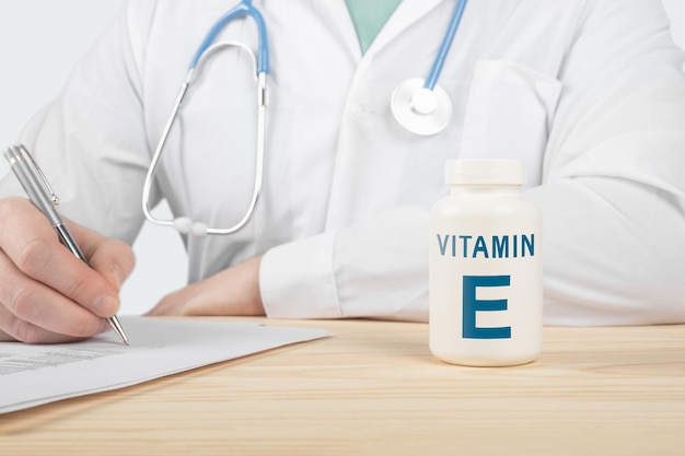 Essentiële vitamine e en mineralen voor de mens. arts raadt aan vitamine e in te nemen. arts praat over de voordelen van vitamine e. e vitamine - gezondheidsconcept