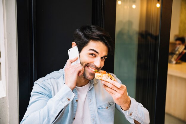 Eten lachende man praten op mobiele telefoon