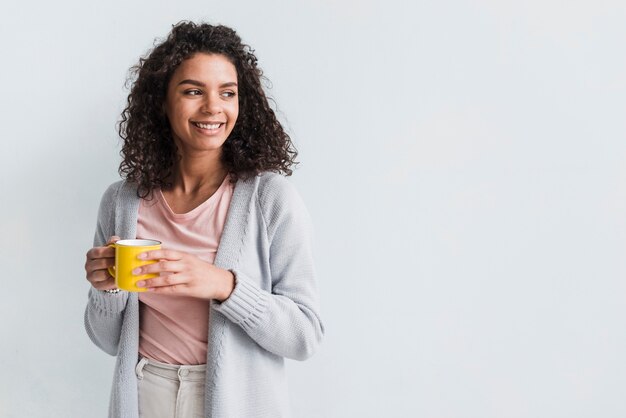 Etnische jonge vrouw met cup op witte achtergrond