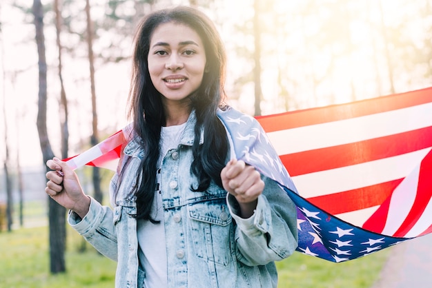 Etnische vrouw met Amerikaanse vlag op schouders