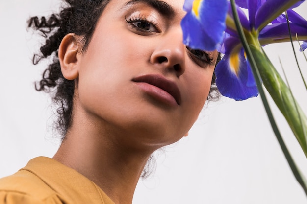 Gratis foto etnische vrouw met boeket van blauwe bloemen