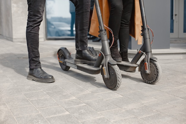 Europees meisje anindische jongen scooters rijden en glimlachen.