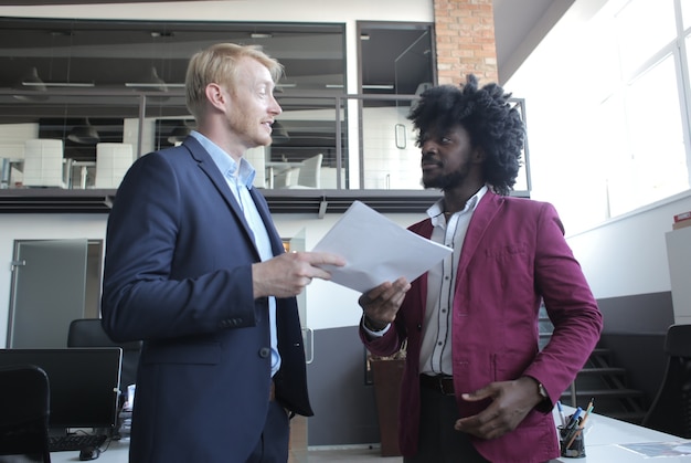Europese en Afro-Amerikaanse zakenpartners die een contract bespreken tijdens een zakelijke bijeenkomst