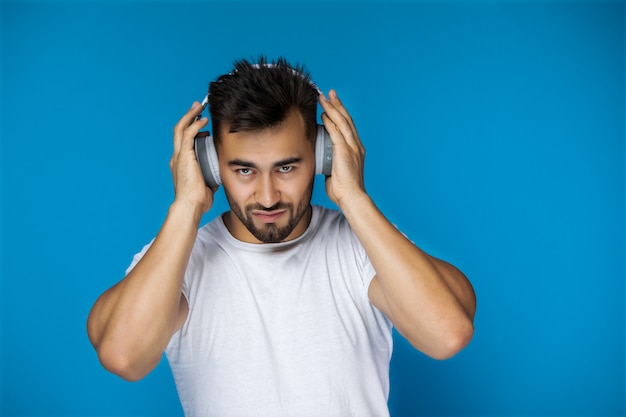 Europese man in wit t-shirt luistert muziek via een koptelefoon