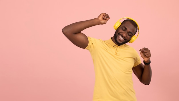 Gratis foto expressieve afro-amerikaanse man die naar muziek luistert