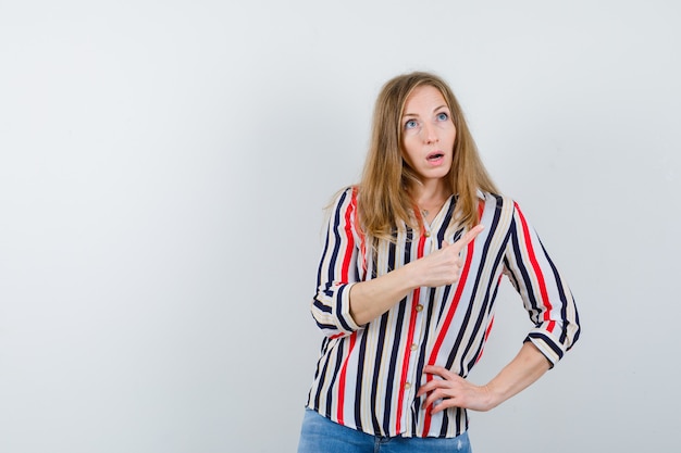 Gratis foto expressieve jonge vrouw poseren in de studio