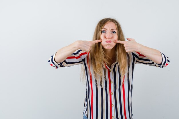 Gratis foto expressieve jonge vrouw poseren in de studio