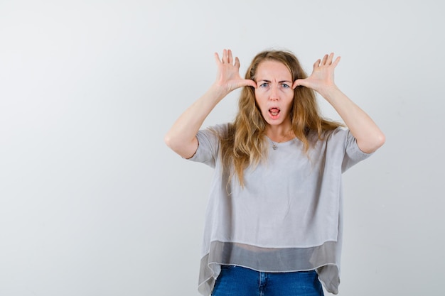 Gratis foto expressieve jonge vrouw poseren in de studio