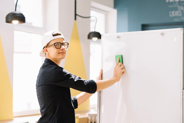 Expressieve schooljongen schoonmaken schoolbord