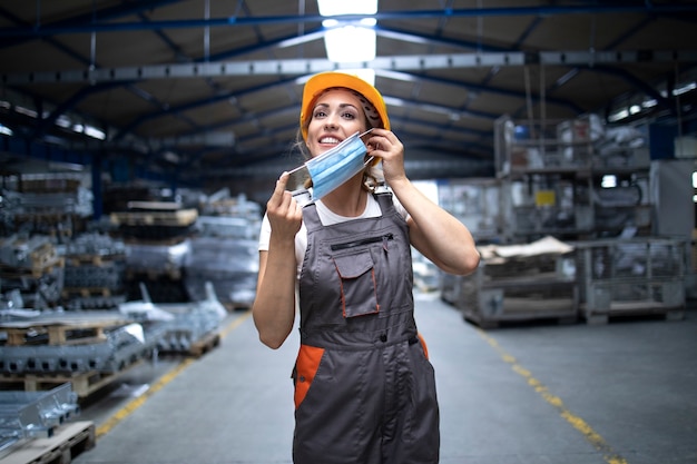 Gratis foto fabrieksarbeider zet een hygiënisch masker op om zichzelf te beschermen tegen het zeer besmettelijke coronavirus