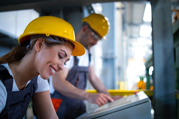 Fabrieksarbeiders in de controlekamer die industriële machines op afstand in de productielijn bedienen