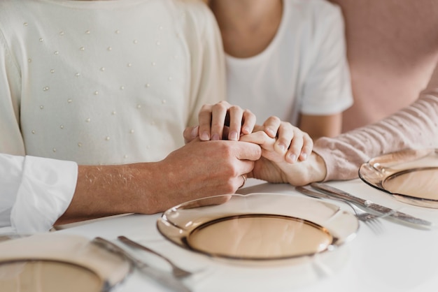 Familie bidden terwijl ze hun handen vasthouden