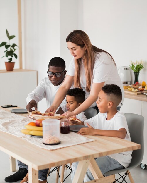 Familie die bereid om pizza te eten wordt