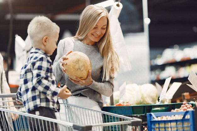 Familie die boodschappen doet. Moeder in grijze trui.