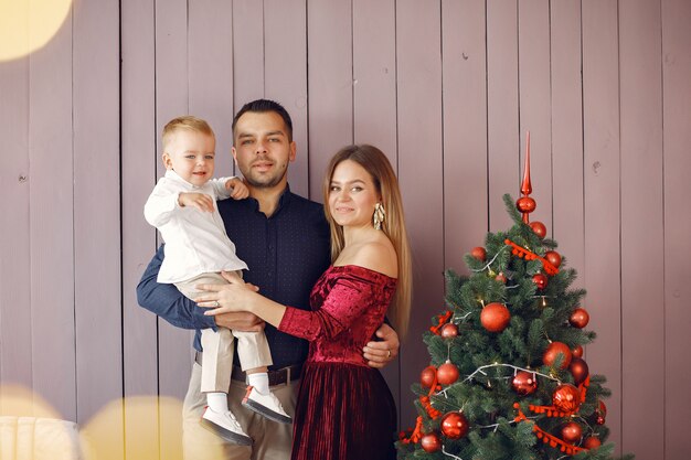 Familie die zich dichtbij Kerstmisboom thuis bevindt